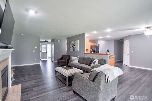 17639 Dusty Ct SW, Tenino, WA 98589 - living room featuring ceiling fan, dark wood-type flooring, baseboards, and a fireplace with flush hearth