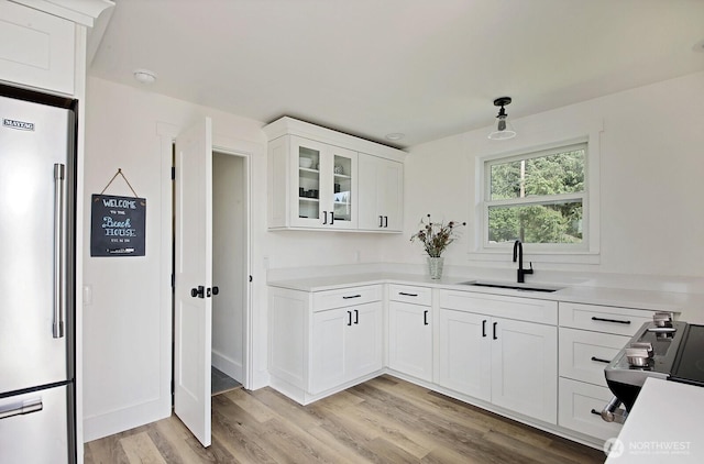 3596 Shell St, Greenbank, WA 98253 - kitchen featuring high end fridge, a sink, white cabinetry, light wood-type flooring, and light countertops