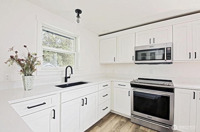 3596 Shell St, Greenbank, WA 98253 - kitchen featuring stainless steel appliances, a sink, light countertops, and white cabinetry
