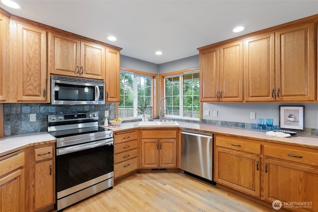 20460 Noll Rd NE, Poulsbo, WA 98370 - kitchen with appliances with stainless steel finishes, a sink, light wood-style flooring, tasteful backsplash, and recessed lighting