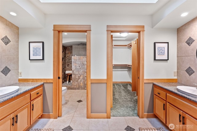 20460 Noll Rd NE, Poulsbo, WA 98370 - full bathroom featuring two vanities, a stall shower, toilet, a spacious closet, and tile patterned floors