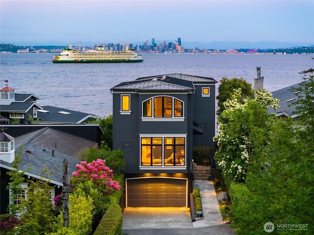 4864 Rockaway Beach Rd NE, Bainbridge Island, WA 98110 - rear view of property featuring a standing seam roof, metal roof, a water view, a garage, and driveway