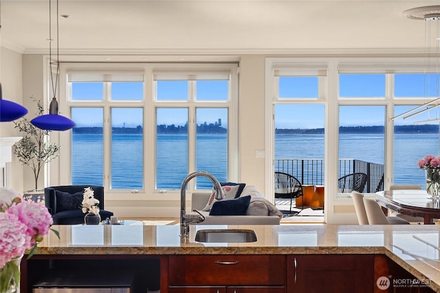 4864 Rockaway Beach Rd NE, Bainbridge Island, WA 98110 - kitchen featuring light stone countertops, ornamental molding, a water view, and a sink
