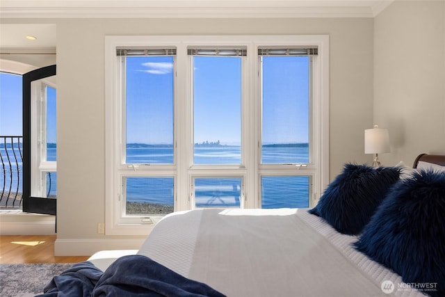 4864 Rockaway Beach Rd NE, Bainbridge Island, WA 98110 - bedroom featuring ornamental molding, wood finished floors, a water view, and baseboards