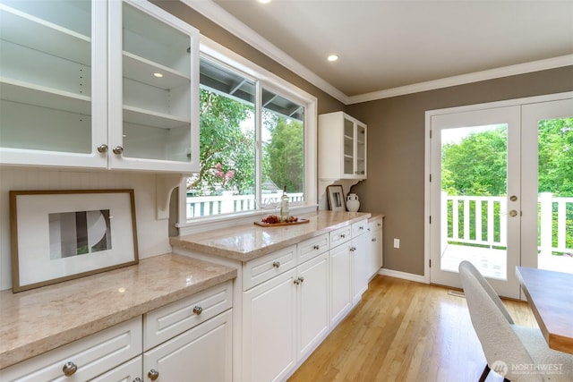 11633 132nd Ct NE, Redmond, WA 98052 - kitchen with crown molding, light wood finished floors, white cabinetry, glass insert cabinets, and light stone counters