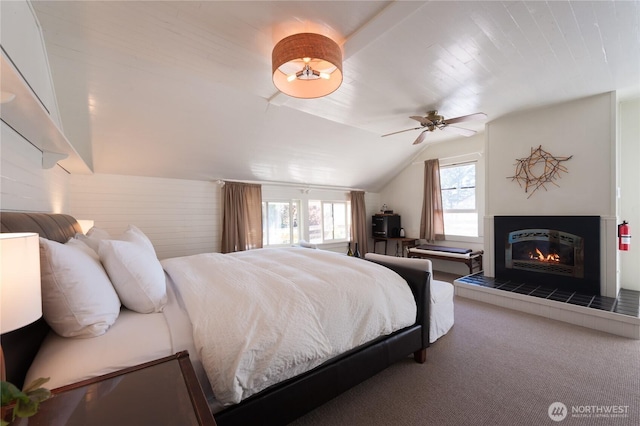 2579 W Shore Dr, Lummi Island, WA 98262 - carpeted bedroom with vaulted ceiling, a ceiling fan, and a tile fireplace