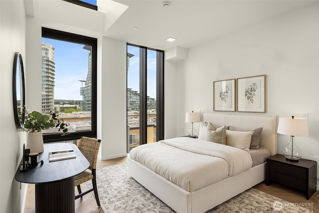 999 110th Ave NE Unit 600, Bellevue, WA 98004 - bedroom featuring wood finished floors and a wall of windows