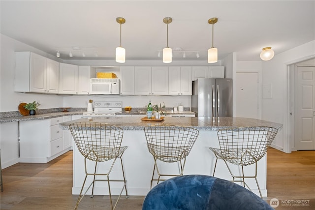 2524 Boyer Ave E Unit 108, Seattle, WA 98102 - kitchen featuring white appliances, a kitchen breakfast bar, and white cabinetry