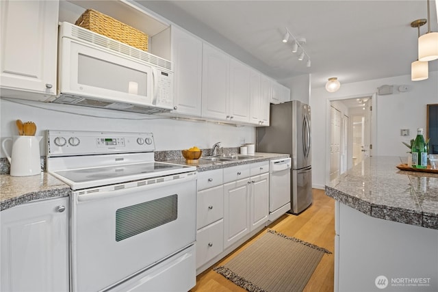 2524 Boyer Ave E Unit 108, Seattle, WA 98102 - kitchen featuring white appliances, white cabinetry, light wood-style flooring, decorative light fixtures, and a sink