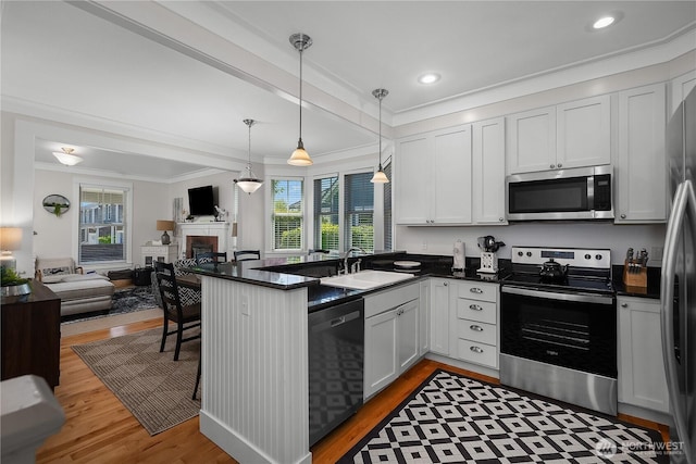 34 Seastar Ln, Pacific Beach, WA 98571 - kitchen with stainless steel appliances, open floor plan, a peninsula, plenty of natural light, and crown molding
