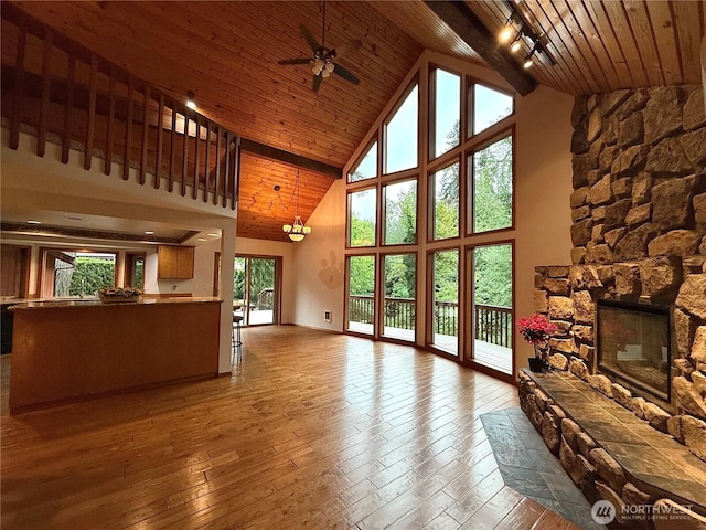 10802 NE 27th Ct, Vancouver, WA 98686 - unfurnished living room with wooden ceiling, high vaulted ceiling, a ceiling fan, hardwood / wood-style floors, and a stone fireplace