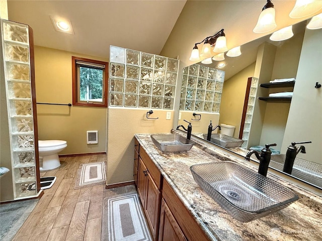 10802 NE 27th Ct, Vancouver, WA 98686 - bathroom featuring toilet, wood finished floors, heating unit, lofted ceiling, and double vanity