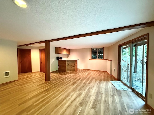 10802 NE 27th Ct, Vancouver, WA 98686 - unfurnished living room with light wood finished floors, a textured ceiling, baseboards, and bar
