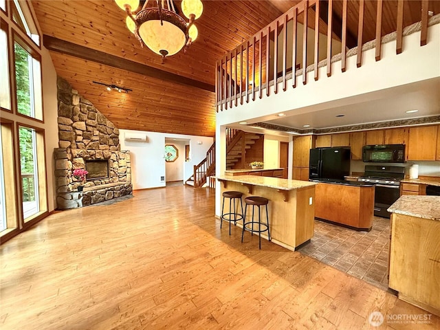 10802 NE 27th Ct, Vancouver, WA 98686 - kitchen with black appliances, high vaulted ceiling, a peninsula, a wall mounted air conditioner, and open floor plan