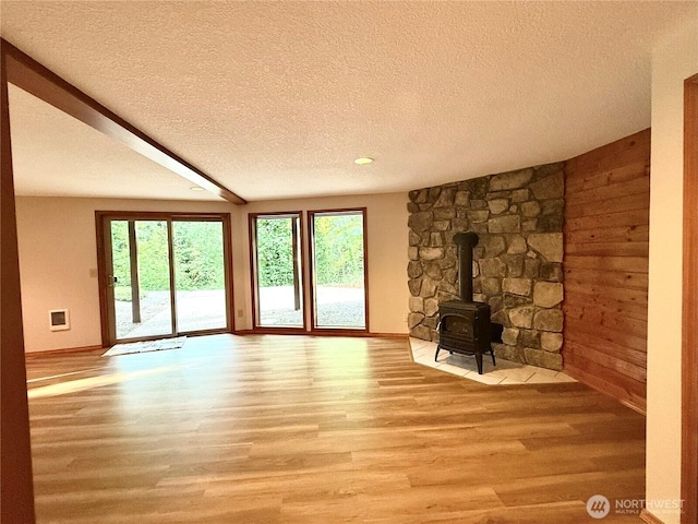 10802 NE 27th Ct, Vancouver, WA 98686 - unfurnished living room with wood finished floors, a textured ceiling, a wood stove, and baseboards