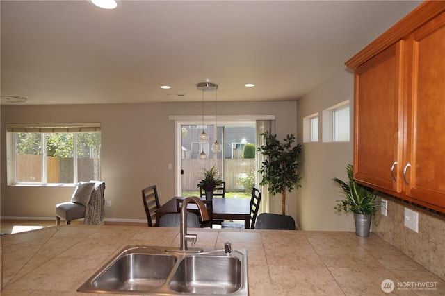 26133 242nd Ave SE, Maple Valley, WA 98038 - kitchen with a sink, brown cabinets, light countertops, healthy amount of natural light, and recessed lighting