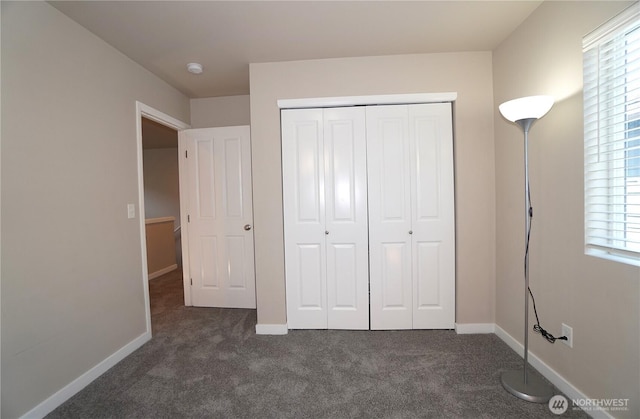 26133 242nd Ave SE, Maple Valley, WA 98038 - unfurnished bedroom featuring dark colored carpet, a closet, and baseboards
