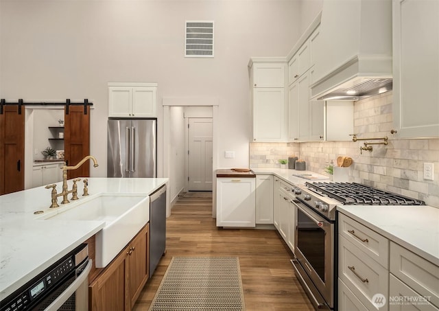 11407 73rd Ave NE, Arlington, WA 98223 - kitchen with high quality appliances, custom exhaust hood, dark wood finished floors, a sink, and white cabinetry