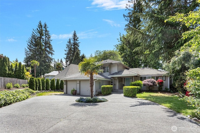 26005 225th Ct SE, Maple Valley, WA 98038 - view of front facade featuring concrete driveway, a garage, a tile roof, and stucco siding