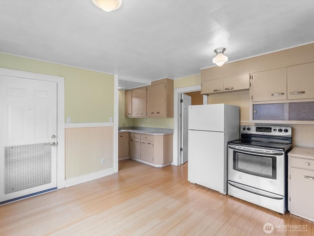 4116 25th Ave SW, Seattle, WA 98106 - kitchen featuring electric stove, freestanding refrigerator, light wood-type flooring, light countertops, and a wainscoted wall