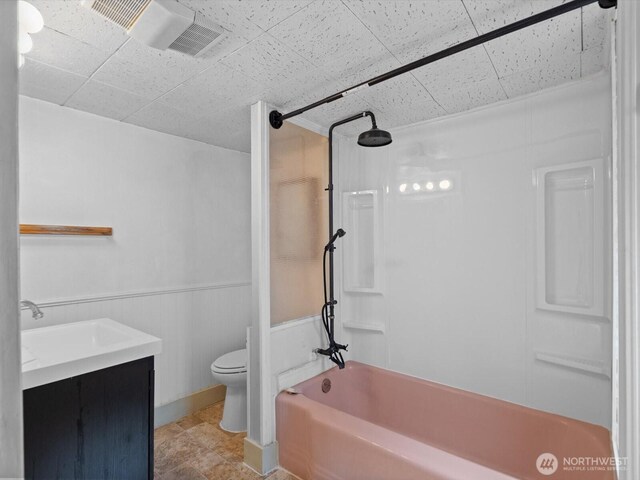 4116 25th Ave SW, Seattle, WA 98106 - bathroom featuring bathtub / shower combination, toilet, vanity, a wainscoted wall, and a drop ceiling