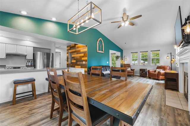 140 E Mountain View Dr, Allyn, WA 98524 - dining room featuring light wood finished floors, ceiling fan, lofted ceiling, and a fireplace with flush hearth