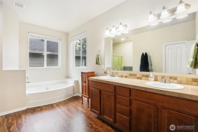 2529 10th Ct SE, Olympia, WA 98501 - bathroom with double vanity, wood finished floors, a bath, and baseboards