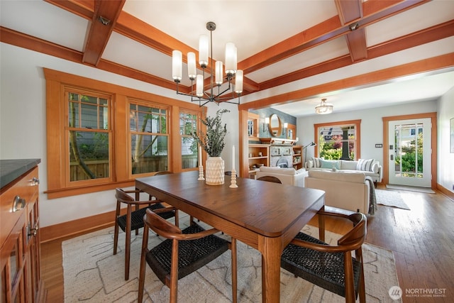 528 N 83rd St, Seattle, WA 98103 - dining room featuring a chandelier, beamed ceiling, wood finished floors, and baseboards