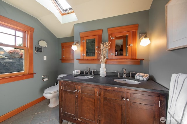 528 N 83rd St, Seattle, WA 98103 - full bathroom with a skylight, vaulted ceiling, double vanity, toilet, and baseboards