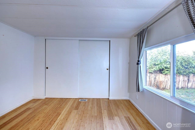 7300 V Pl, Long Beach, WA 98631 - unfurnished bedroom featuring wood finished floors, multiple windows, and a closet
