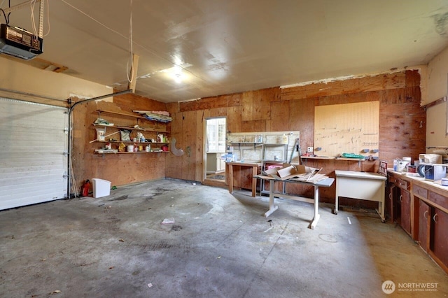 7300 V Pl, Long Beach, WA 98631 - garage featuring a garage door opener, a workshop area, and wood walls