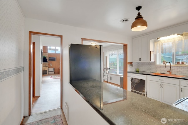 284 Division Ave, Morton, WA 98356 - kitchen featuring dishwashing machine, white cabinetry, a sink, backsplash, and hanging light fixtures