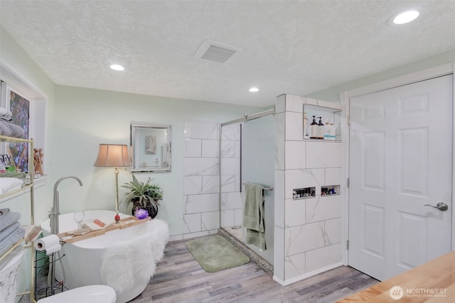 284 Division Ave, Morton, WA 98356 - full bathroom with wood finished floors, tiled shower, a freestanding bath, recessed lighting, and a textured ceiling