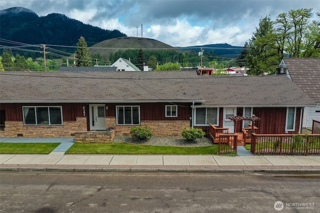 284 Division Ave, Morton, WA 98356 - view of front of home with a mountain view, stone siding, roof with shingles, board and batten siding, and a front yard