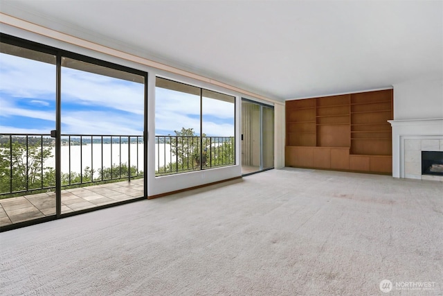 8005 Sand Point Way NE Unit A45, Seattle, WA 98115 - unfurnished living room featuring built in shelves, carpet flooring, a water view, and a tile fireplace