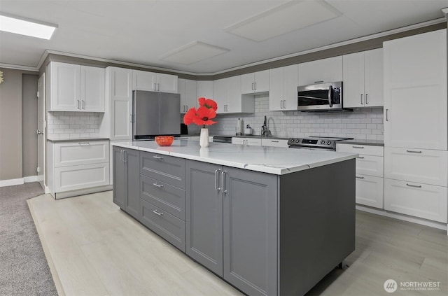 8005 Sand Point Way NE Unit A45, Seattle, WA 98115 - kitchen featuring appliances with stainless steel finishes, gray cabinetry, white cabinetry, tasteful backsplash, and ornamental molding