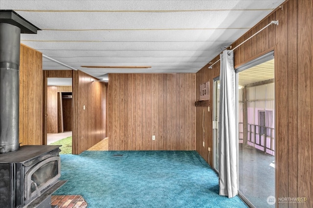 315 Washington St, Pe Ell, WA 98572 - unfurnished living room with a wood stove, wooden walls, and carpet