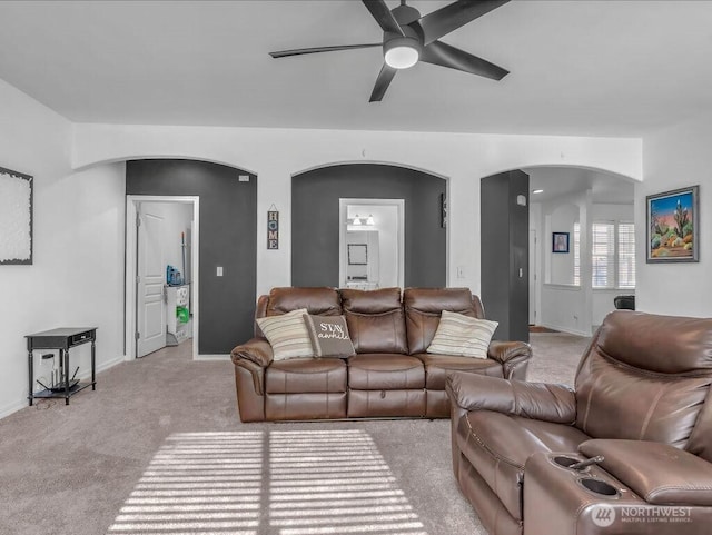 530 N Kentucky Dr, Moses Lake, WA 98837 - living room featuring arched walkways, a ceiling fan, light carpet, and baseboards