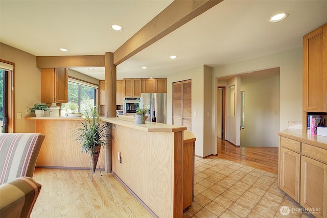 9430 Hoeder Ln, Bothell, WA 98011 - kitchen featuring stainless steel appliances, a peninsula, light countertops, recessed lighting, and light wood-type flooring