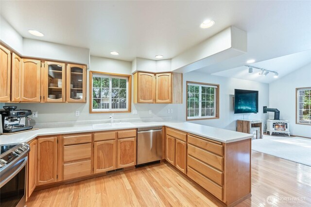 84 Norling Ln, Leavenworth, WA 98826 - kitchen with appliances with stainless steel finishes, a peninsula, a sink, a wood stove, and healthy amount of natural light