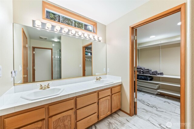 84 Norling Ln, Leavenworth, WA 98826 - full bath featuring marble look tiles, double vanity, a walk in closet, and a shower with door