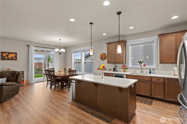 509 L NE, Quincy, WA 98848 - kitchen featuring a sink, open floor plan, brown cabinetry, stainless steel dishwasher, and a chandelier