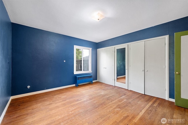 2830 Elm St, Bellingham, WA 98225 - unfurnished bedroom featuring radiator heating unit, wood finished floors, multiple closets, and baseboards