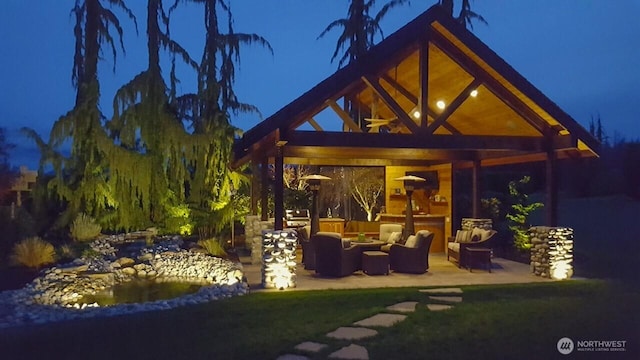 11504 128th Dr NE, Lake Stevens, WA 98258 - back of house at night with a gazebo, an outdoor hangout area, and a patio
