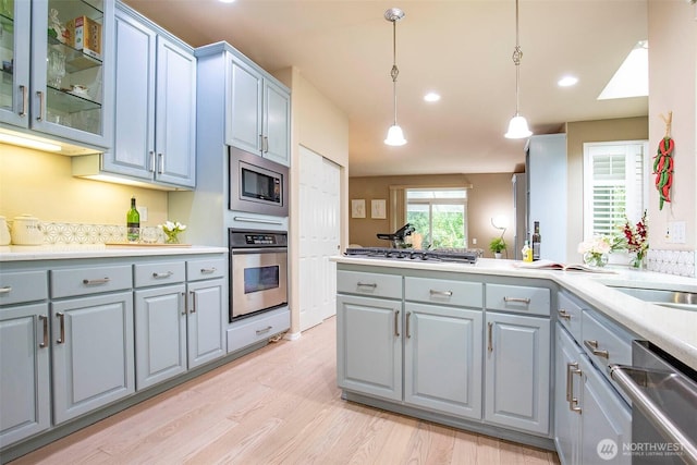 19 198th Pl SE, Bothell, WA 98012 - kitchen with stainless steel appliances, gray cabinets, light wood finished floors, hanging light fixtures, and light countertops