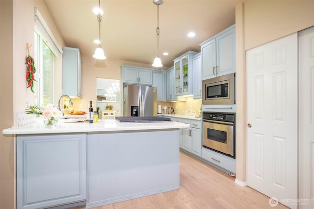 19 198th Pl SE, Bothell, WA 98012 - kitchen with appliances with stainless steel finishes, a peninsula, glass insert cabinets, light wood finished floors, and light countertops