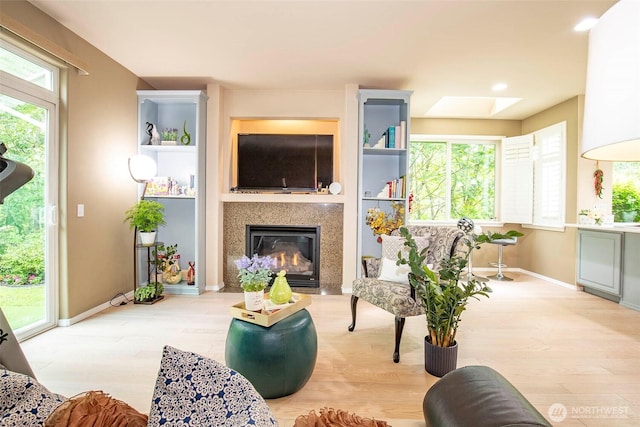 19 198th Pl SE, Bothell, WA 98012 - living room with light wood finished floors, a skylight, a glass covered fireplace, baseboards, and recessed lighting