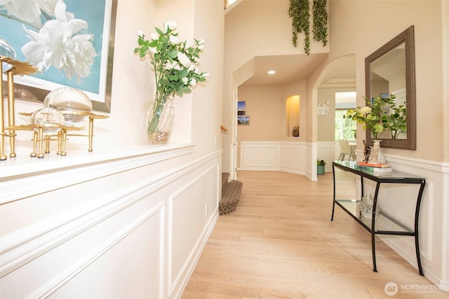 19 198th Pl SE, Bothell, WA 98012 - hallway featuring arched walkways, a decorative wall, light wood finished floors, and wainscoting
