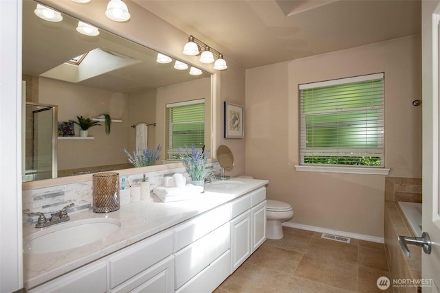 19 198th Pl SE, Bothell, WA 98012 - full bath featuring double vanity, a skylight, baseboards, toilet, and a relaxing tiled tub
