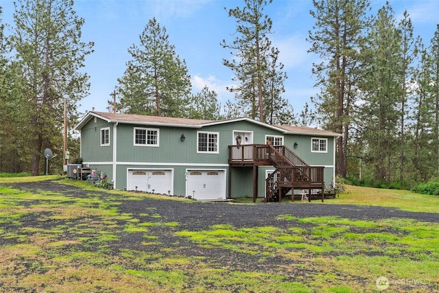 4224 N Brooks Rd, Medical Lake, WA 99022 - rear view of house with stairway, a deck, driveway, a garage, and a cooling unit